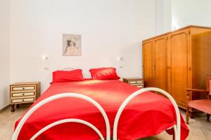 ein Schlafzimmer mit einem roten Bett und einem Holzschrank in der Unterkunft Monolocale Volta in Nardò