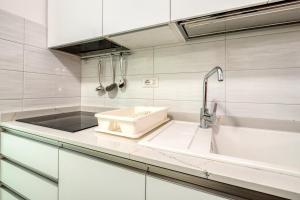 Eine weiße Küche mit Spüle und Arbeitsplatte in der Unterkunft Monolocale Volta in Nardò + 18 Fotos