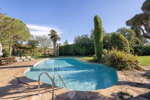 a swimming pool in a yard with trees and bushes at La Masia in El Bruc