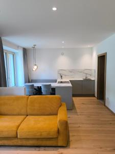 a living room with a couch and a kitchen at Die entspannende Eiche in San Pancrazio dʼUltimo