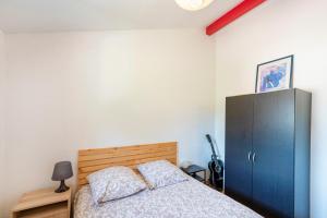 a bedroom with a bed and a blue cabinet at Maison Chaleureuse Avec Terrasse in Capbreton