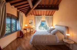a bedroom with a bed and a desk and windows at Podere Bucigattolo in Serravalle Pistoiese +36 photos