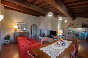 a living room with a red couch and a table at Podere Bucigattolo in Serravalle Pistoiese
