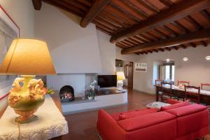 a living room with a red couch and a fireplace at Podere Bucigattolo in Serravalle Pistoiese