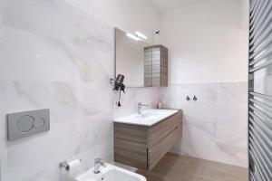 a white bathroom with a sink and a mirror at Profumo di Salsedine in Bonassola +16 photos