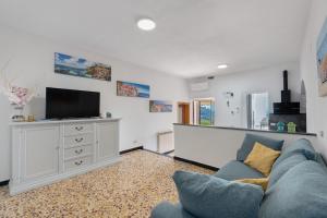 a living room with a blue couch and a tv at Profumo di Salsedine in Bonassola