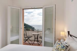 a bedroom with a bed and a view of the ocean at Profumo di Salsedine in Bonassola