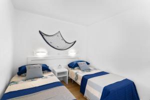 a bedroom with two beds and a net on the wall at Casita Blanca in Puerto Rico de Gran Canaria +17 photos