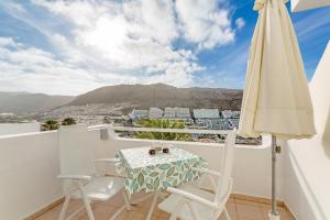 a balcony with a table and chairs and an umbrella at Casita Blanca in Puerto Rico de Gran Canaria