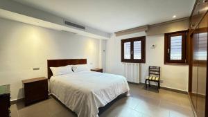 a bedroom with a bed and a table and windows at Best Leisure in Playa de Palma in Can Pastilla