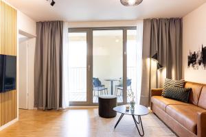 a living room with a couch and a table at AlegraStay Apartments - Dresden City in Dresden