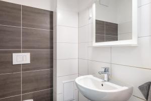 a white bathroom with a sink and a mirror at Großes Ferienhaus Im Grünen - in Dummerstorf +23 photos