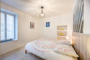 a bedroom with a bed with a comforter on it at Agréable Maison Sablaise in Les Sables-d'Olonne