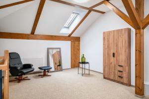 an attic room with a chair and a door at Großes Ferienhaus Im Grünen - in Dummerstorf