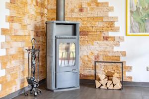 a wood stove in front of a brick wall at Großes Ferienhaus Im Grünen - in Dummerstorf