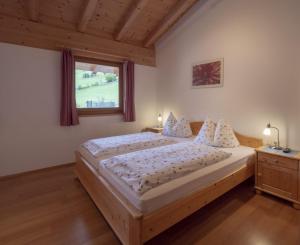 a bedroom with a large bed and a window at Huberhof Mareit in Mareta +26 photos