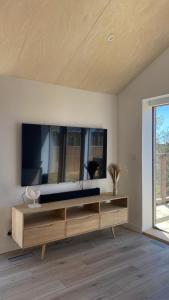 a living room with a large television on a wall at Villa Grande Est idéal famille Spa in Plounéour-Trez
