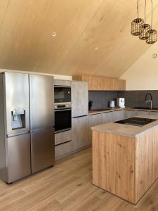 a kitchen with stainless steel appliances and wooden floors at Villa Grande Est idéal famille Spa in Plounéour-Trez