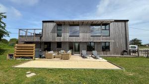 a house with chairs in front of it at Villa Grande Est idéal famille Spa in Plounéour-Trez