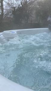 a bath tub filled with water in a yard at Villa Grande Est idéal famille Spa in Plounéour-Trez