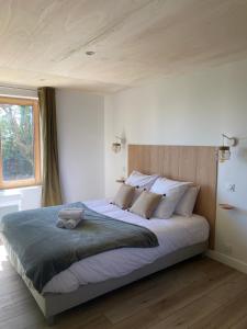 a bedroom with a large bed with a wooden headboard at Villa Grande Est idéal famille Spa in Plounéour-Trez +31 photos