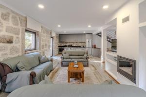 a living room with two couches and a table at Casa Vilarinha Gerês in Bouro +12 photos