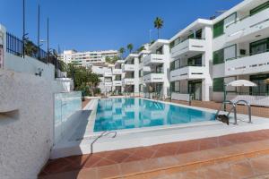 a swimming pool in front of a apartment building at Apartamento Yumbo Centro in Maspalomas