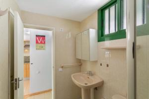a small bathroom with a sink and a window at Apartamento Yumbo Centro in Maspalomas +16 photos