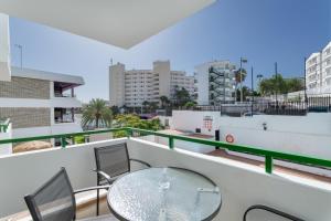 a balcony with a glass table and chairs at Apartamento Yumbo Centro in Maspalomas