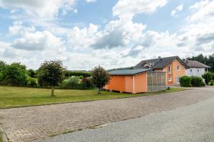 an orange house on the side of a road at Ferienwohnungen Mayerhofer in Arnstorf