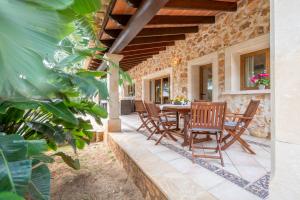 an outdoor patio with a wooden table and chairs at Casa Brava in Santanyi