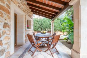 a patio with a table and chairs under a wooden ceiling at Casa Brava in Santanyi