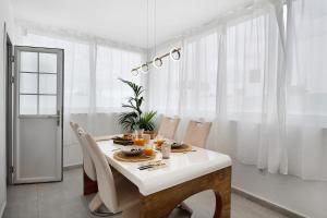 a white dining room with a table and chairs at Villa Khaleesi in Playa Blanca