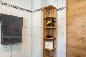 a bathroom with a shower with wooden shelves at Ferienwohnungen Mayerhofer in Arnstorf