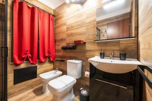 a bathroom with a toilet and a sink and a red curtain at Attilio's House in Capoterra