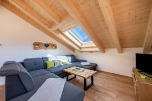 a living room with a blue couch and a window at Ferienwohnung Susi im Neubau in Farchant