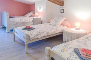 a bedroom with two beds and a table at Le Logis Chez Bompain in Brizambourg