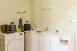a bathroom with a washing machine and a sink at Le Logis Chez Bompain in Brizambourg