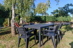 a table and chairs sitting in the grass at Le Logis Chez Bompain in Brizambourg