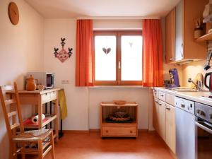a kitchen with a window with a fire in it at Haus Jurisch in Urberg +29 photos