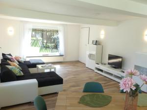 a living room with a couch and a tv at Ferienhaus Villa Wolffsschlucht in Oberzent