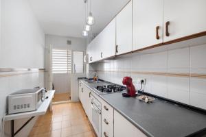 a kitchen with white cabinets and a red mixer on a counter at Oasis in Sitges