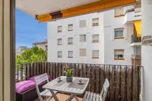 a balcony with a table and chairs and a building at Oasis in Sitges