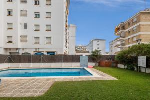 a swimming pool in front of a building at Oasis in Sitges