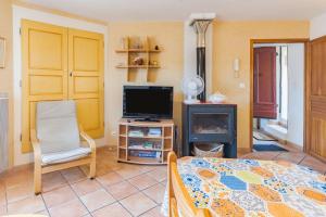 a living room with a television and a table at L'amourié, Rdc, Gîte 4 Personnes in Sainte-Croix-de-Verdon