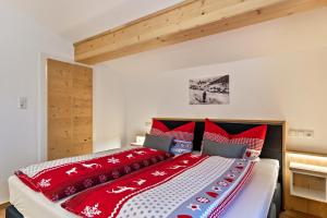 a bedroom with a large bed with red pillows at Bergwelt A2 in Niederau