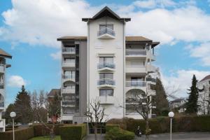 a tall white apartment building with a roof at Annecy Garden Spa Billiards in Annecy