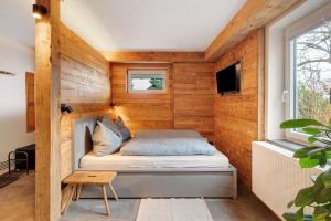 a small bedroom with a bed in a wooden wall at Wanderer Lodge am Breitenstein in Bissingen an der Teck