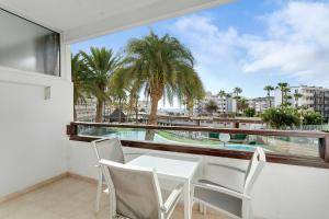 a balcony with a table and chairs and a view of the ocean at Nice Apartment 1210 In Central Area in San Bartolomé