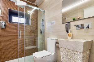 a bathroom with a shower and a toilet and a sink at Villa Marel in Cerdillo +18 photos